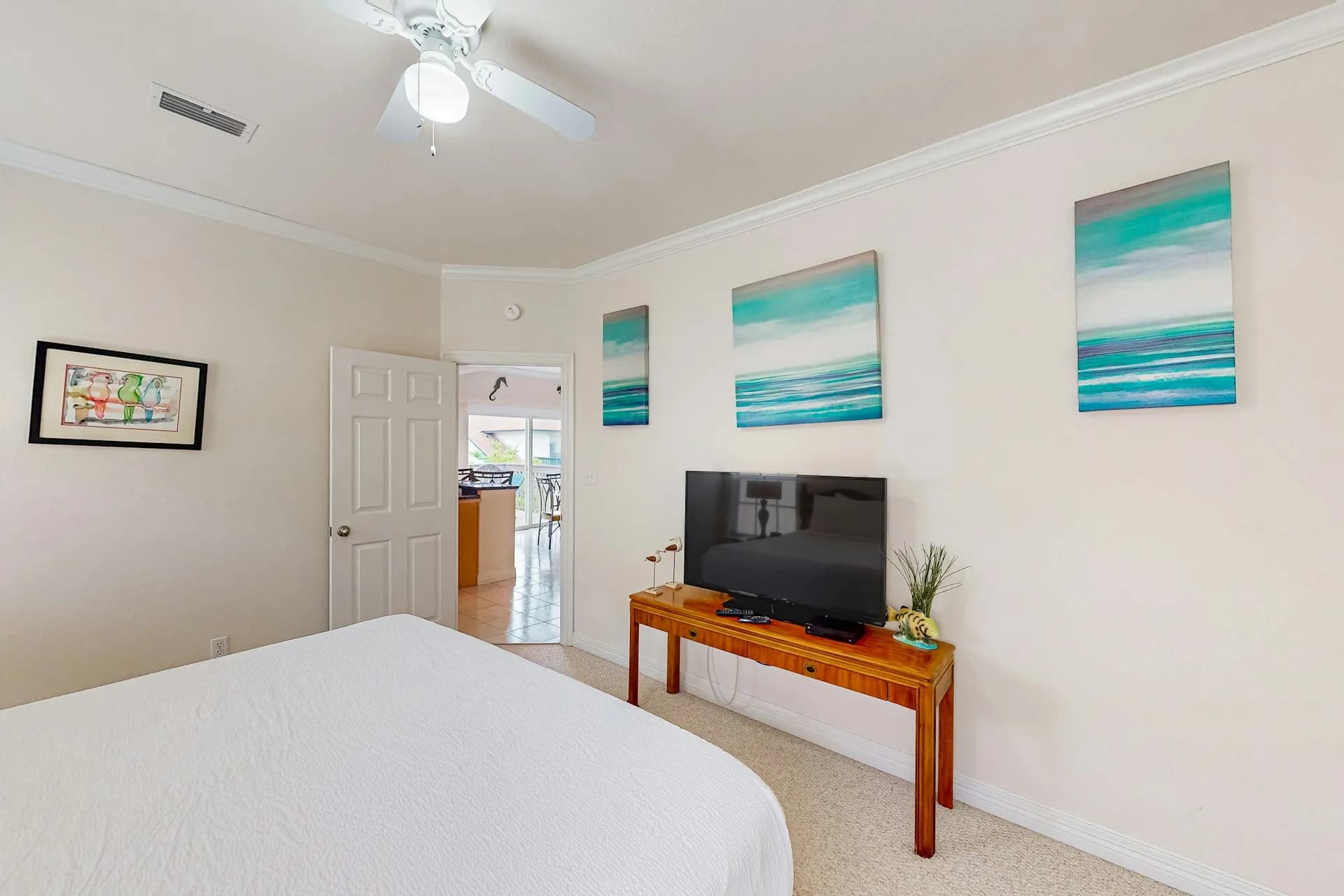 Master bedroom with TV and ocean-themed artwork